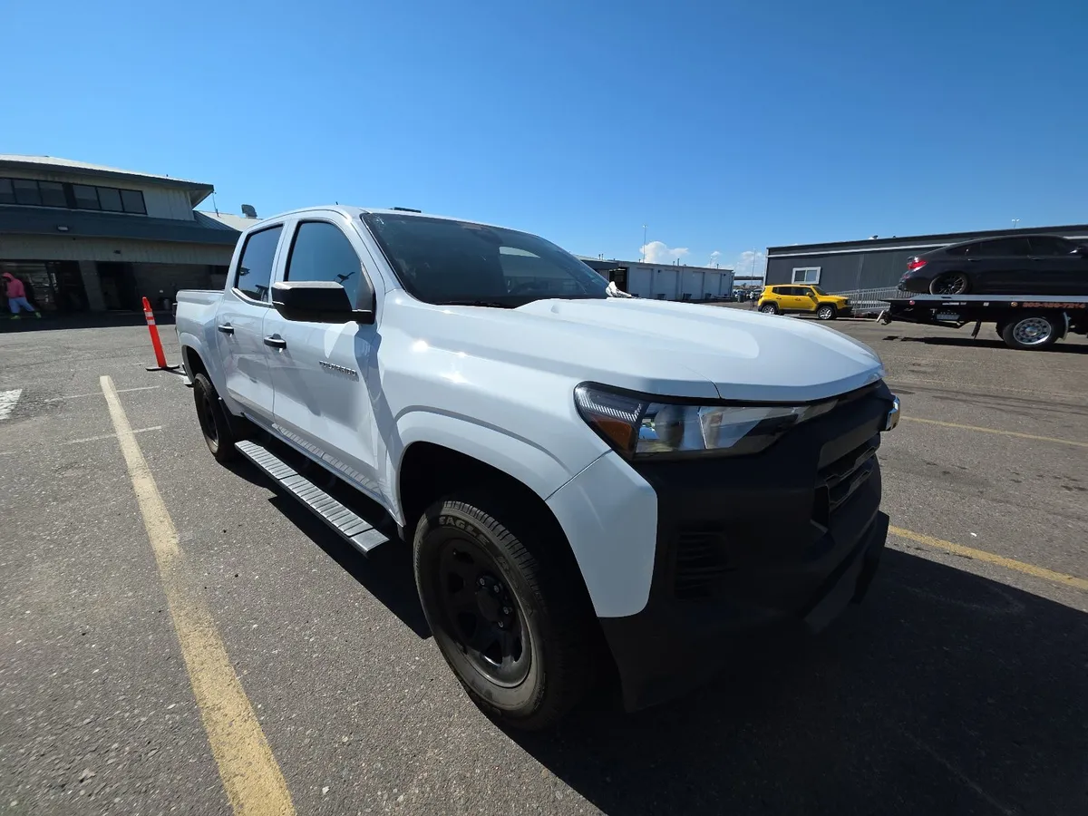 2024 Chevrolet Colorado Work Truck crew cab in white with black wheels and running boards, front three-quarter view on the auction lot