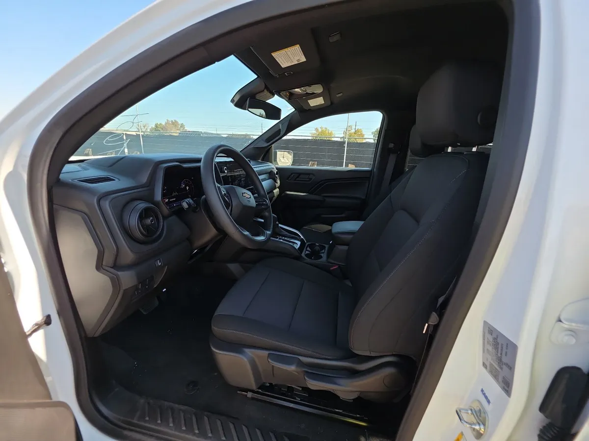 Interior of the 2024 Chevrolet Colorado Work Truck showing black cloth seats and the digital gauge cluster