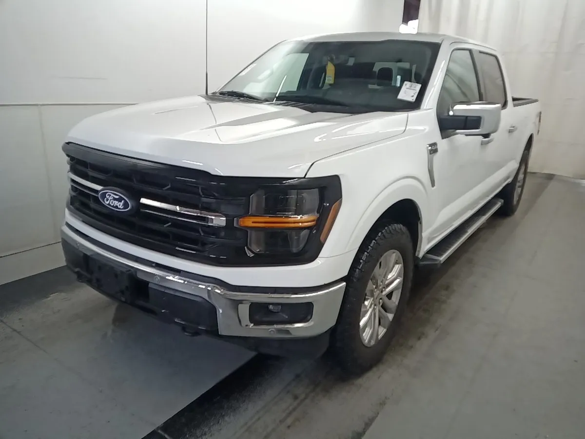 2024 Ford F-150 XLT SuperCrew in white with chrome bumper and running boards, front three-quarter view in the auction photo booth