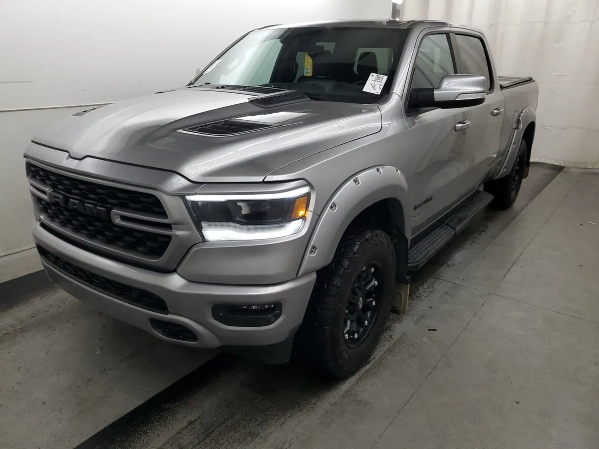 2022 Ram 1500 Sport crew cab in silver with a black grille, fender flares and black wheels, front three-quarter view in the auction photo booth