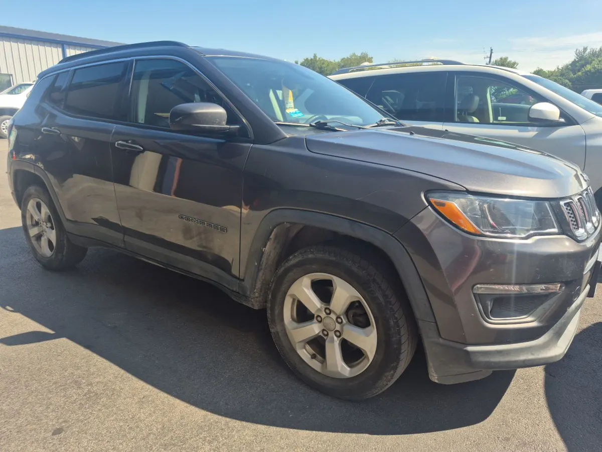 2017 Jeep Compass Latitude in dark gray, front three-quarter view on the auction lot in bright sun