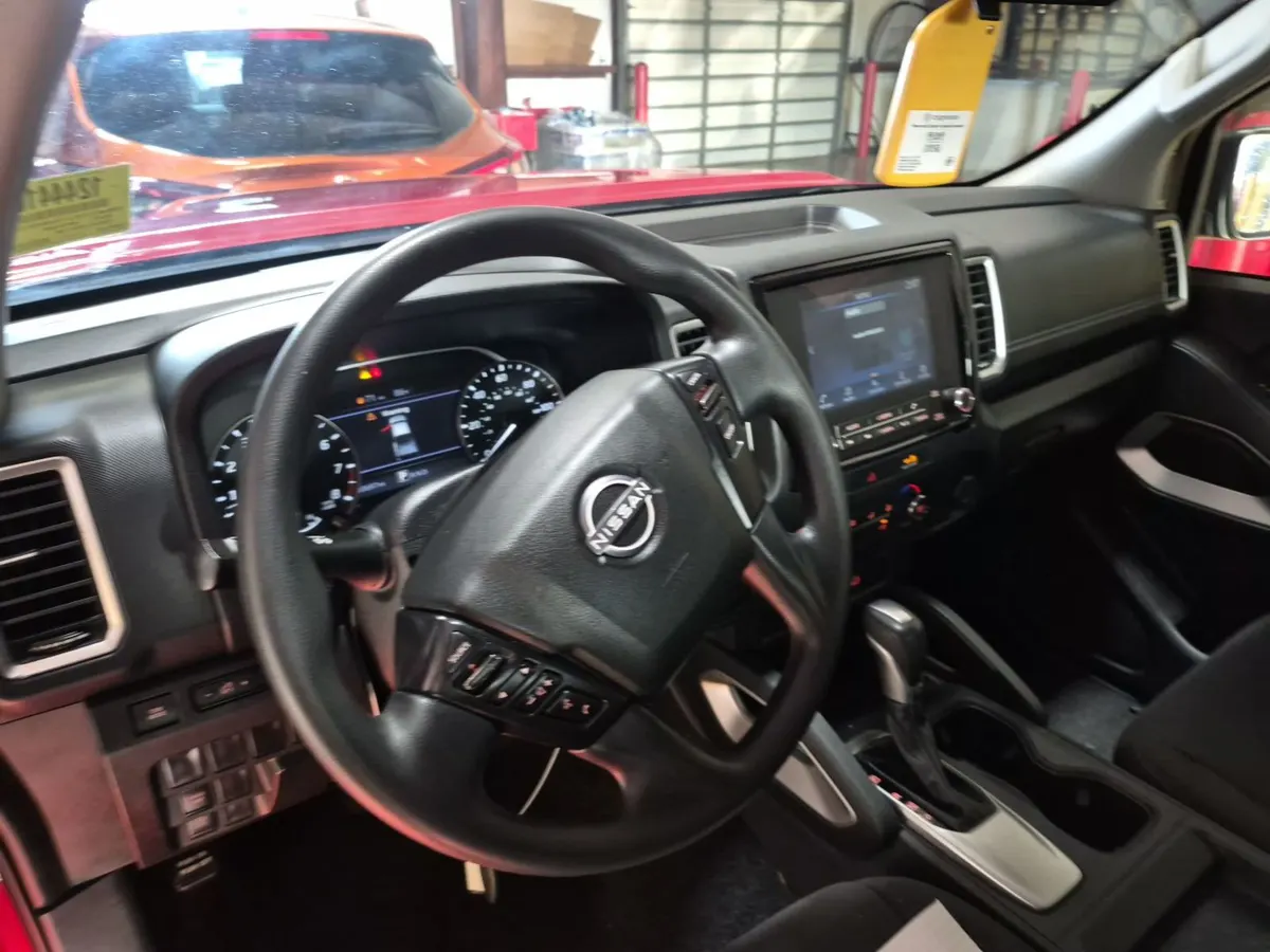 Interior of the 2022 Nissan Frontier SV showing the steering wheel, digital gauge cluster and touchscreen