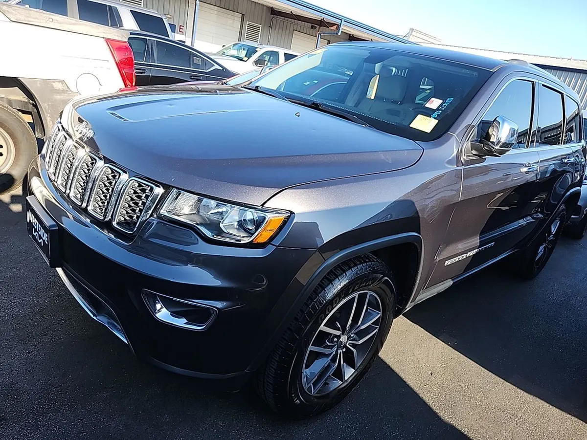 2018 Jeep Grand Cherokee Limited in gray with chrome grille and dark alloy wheels, front three-quarter view on the auction lot