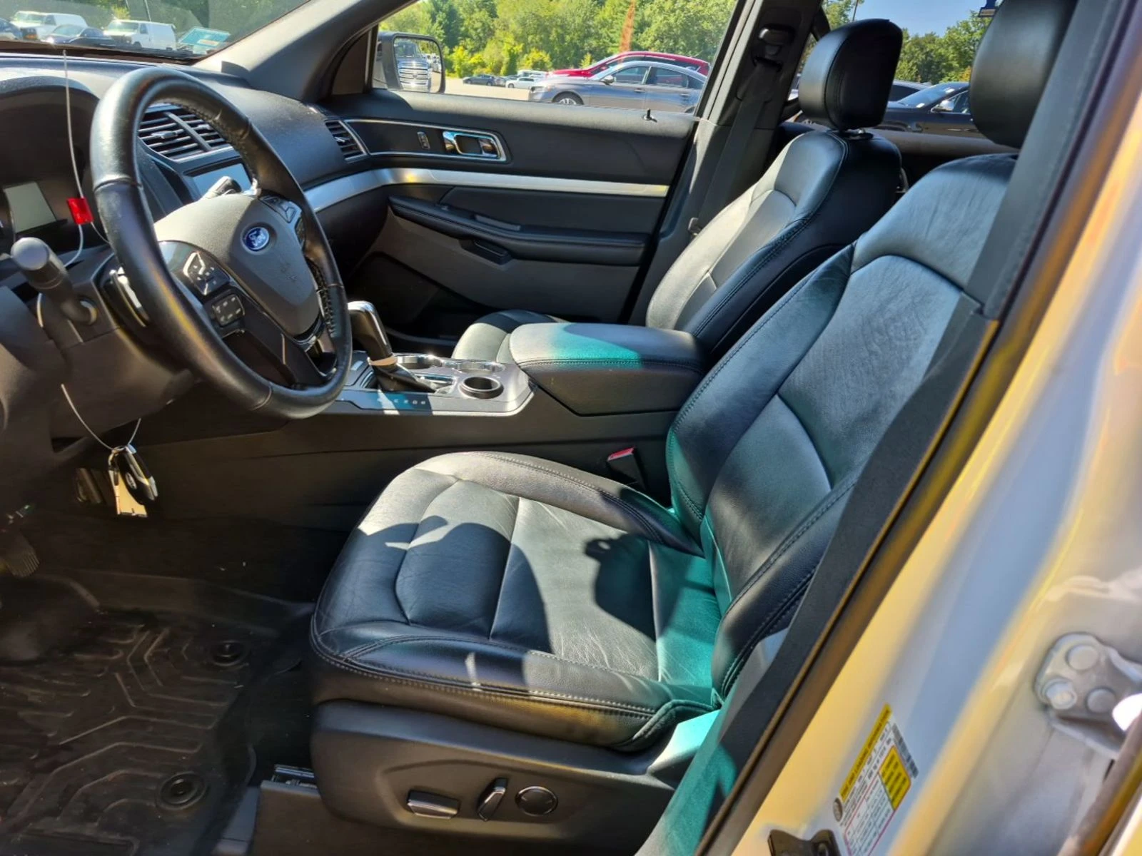 Interior of the 2017 Ford Explorer XLT showing black leather front seats, wood-look trim, and center stack