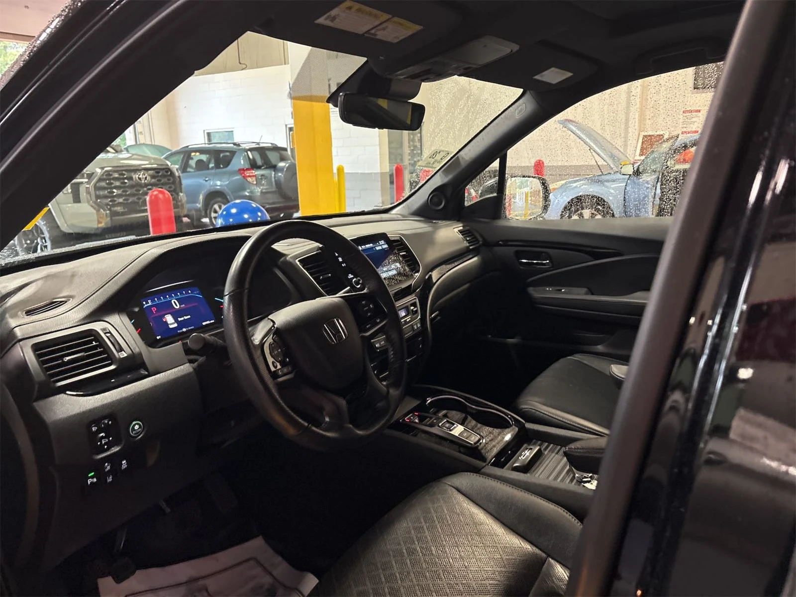 Interior of the 2019 Honda Passport Touring showing black leather seats, large touchscreen, and clean modern dashboard