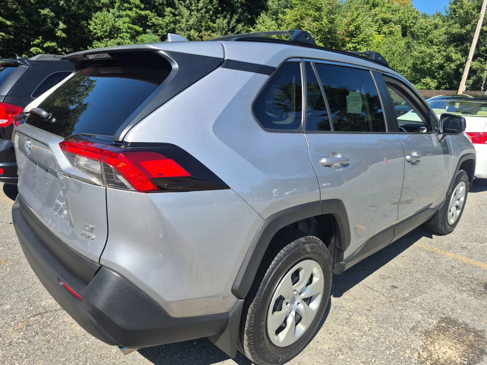 Rear three-quarter view of the 2021 Toyota RAV4 LE in silver showing the LE AWD badge and clean tailgate
