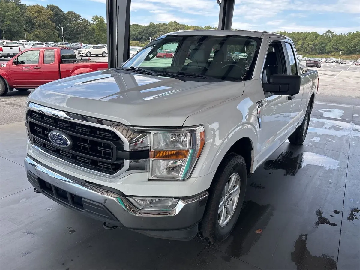 2021 Ford F-150 XLT extended cab in white, front three-quarter view under the auction canopy