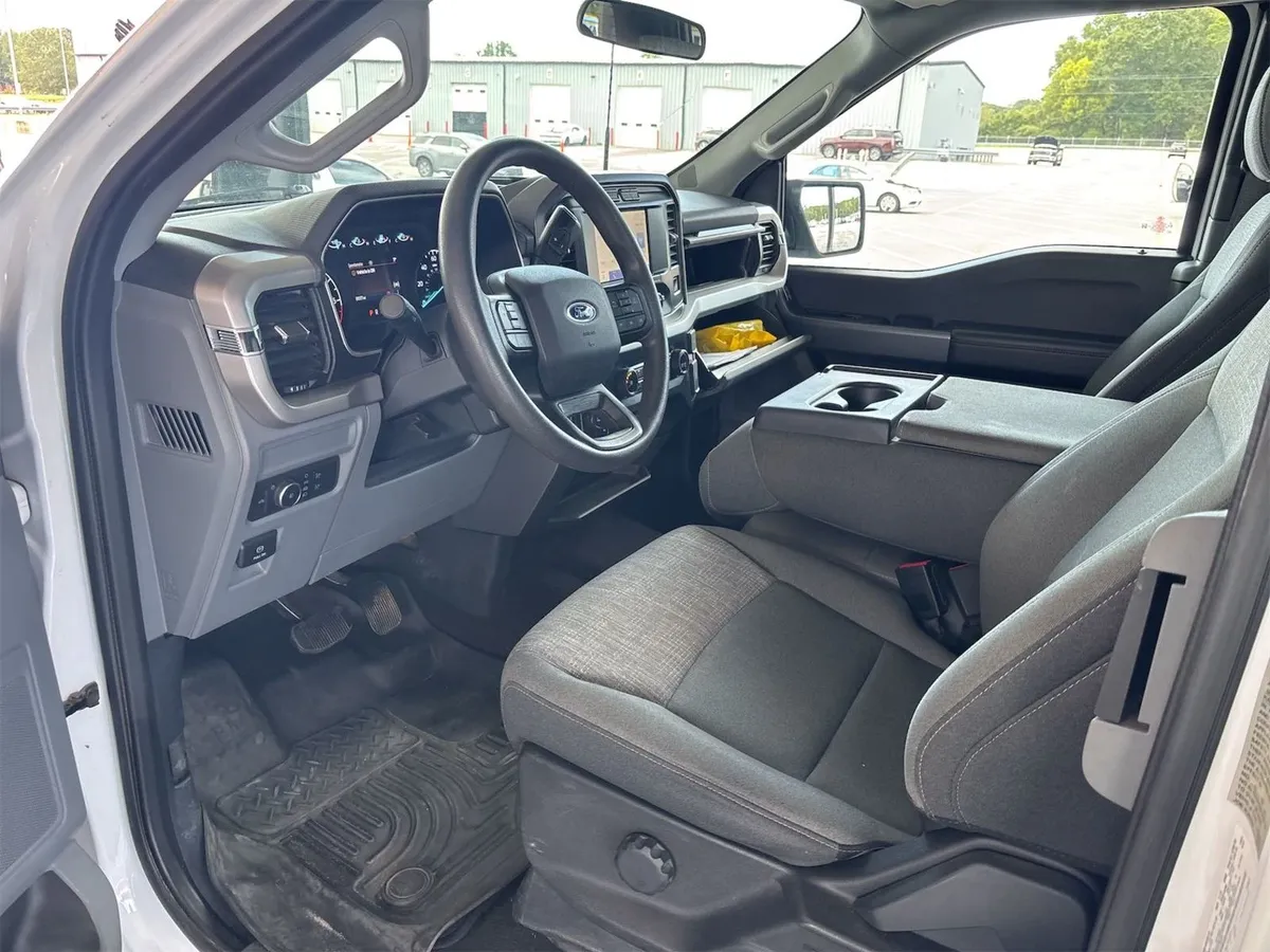 Interior of the 2021 Ford F-150 XLT showing gray cloth seats, center console, and a clean dash