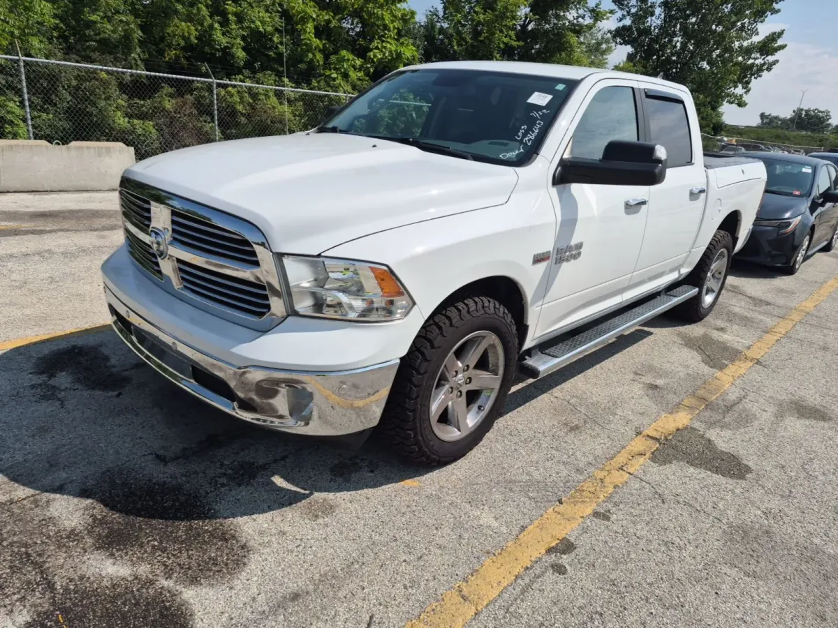 2018 Ram 1500 Big Horn four-door pickup in white with running boards and all-terrain tires, front three-quarter view on the auction lot
