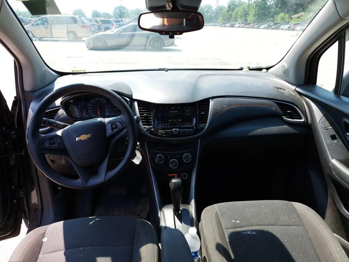 Interior of the 2022 Chevrolet Trax LS with black cloth seats and a dusty dash